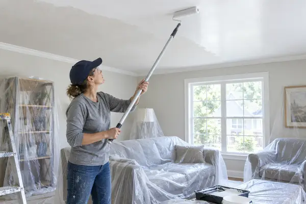 Painting a ceiling with a roller on an extension pole