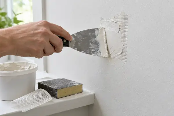 Patching a hole in drywall with spackle and a mesh patch